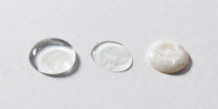 Clear silicone primer gel droplet resting next to lightweight water-based primer fluid